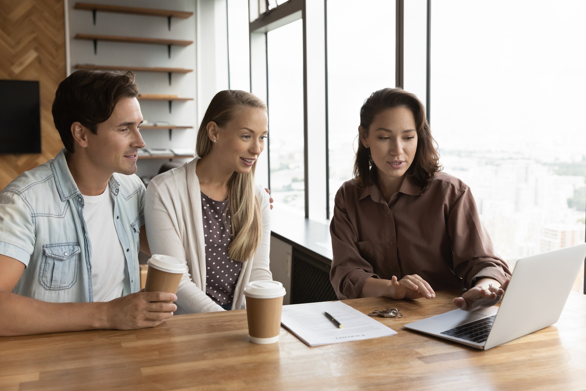 Female relator consult excited couple clients in office